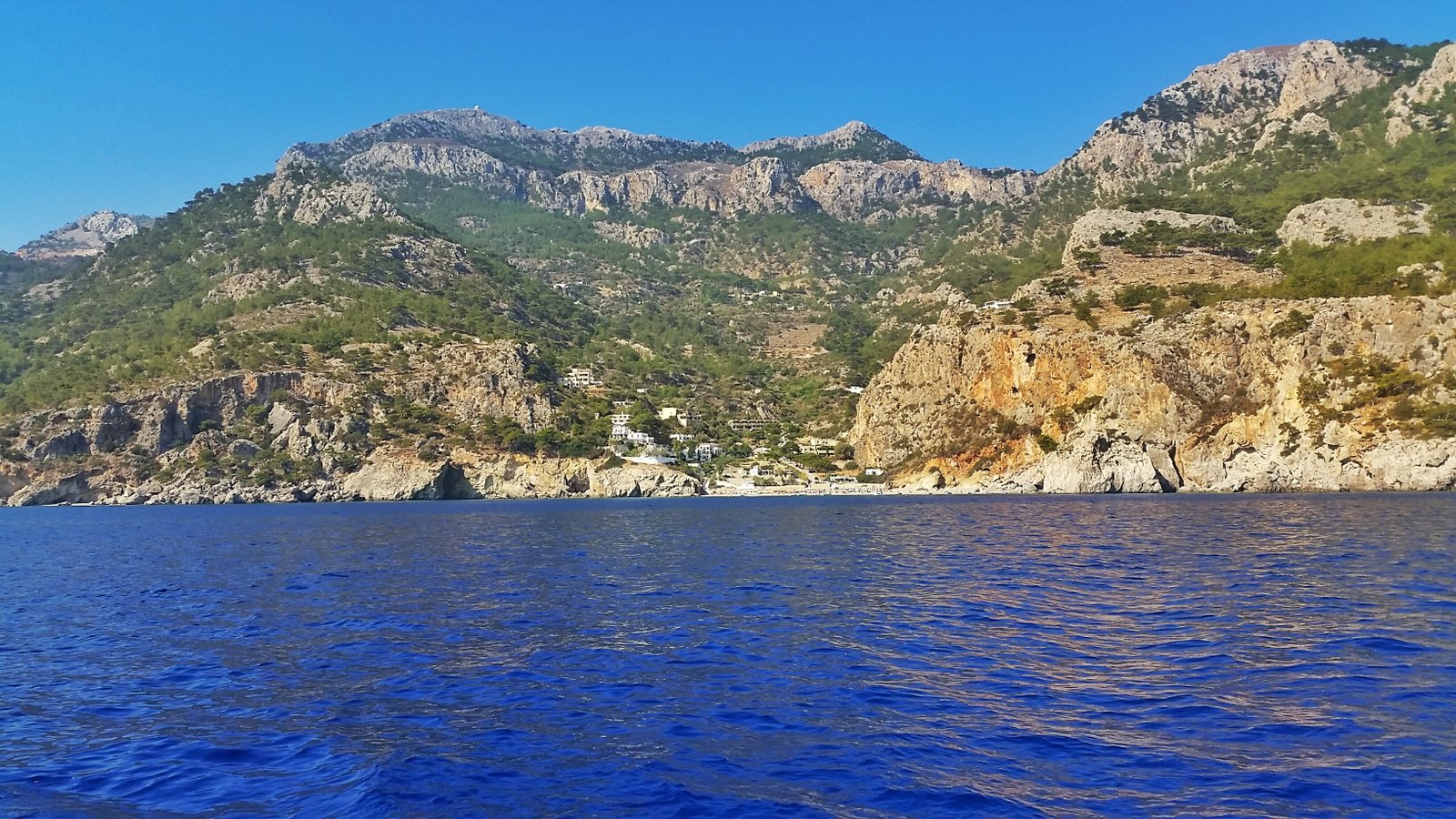 Spiaggia deserta con montagne rosa sullo sfondo nella costa est di Karpathos