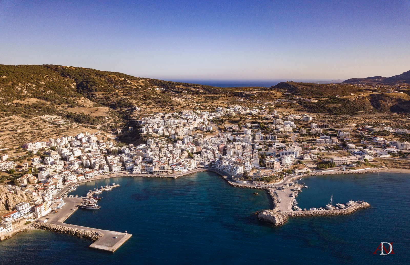 Piccola chiesa con cupole rosse affacciata sul porto di un'isola greca