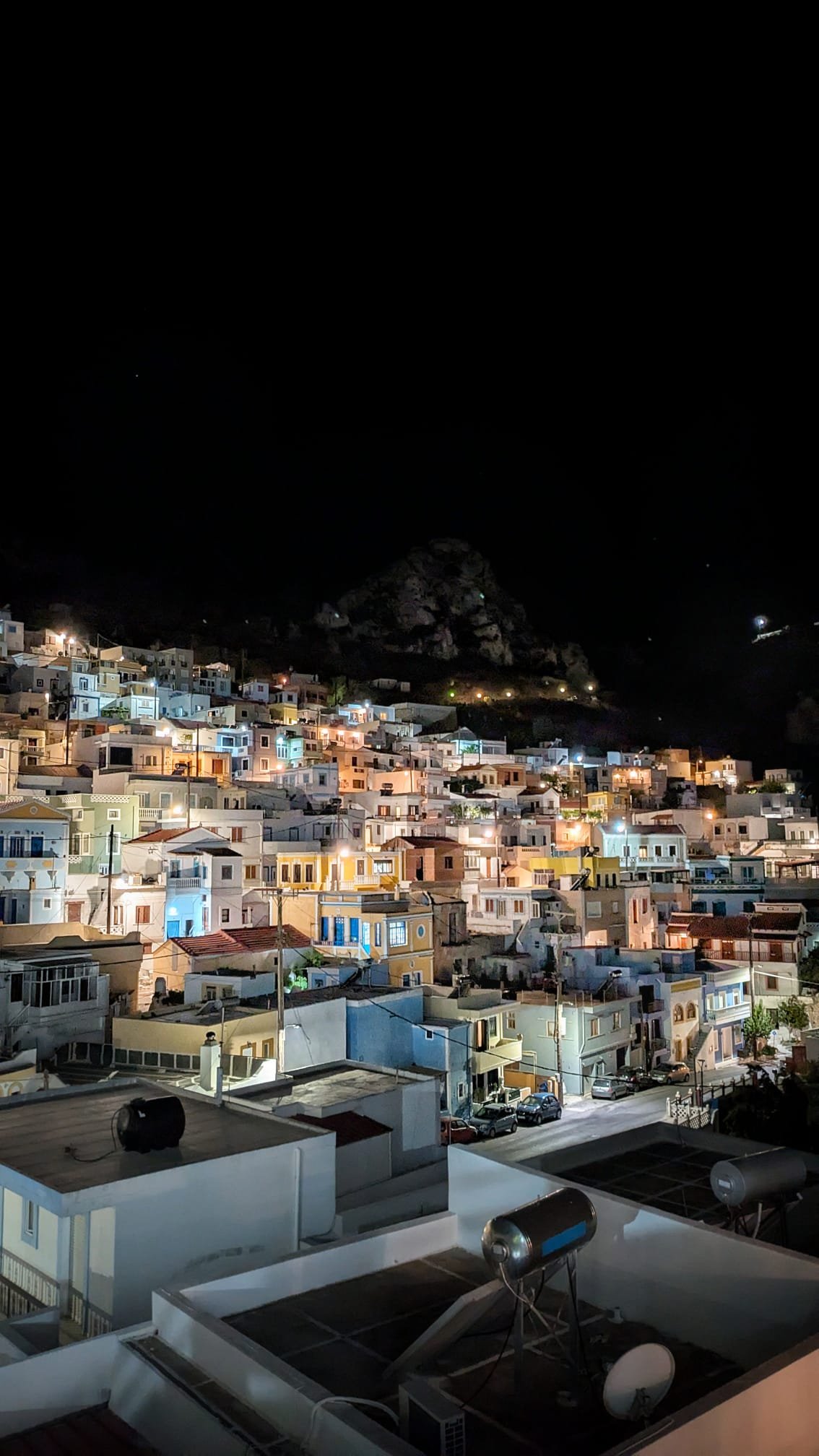 Villaggio di Karpathos illuminato nelle ore serali con le luci delle case e del porto